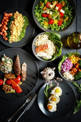 Various culinary dishes on a dark wooden table. Exquisite restaurant serve on dark dishes