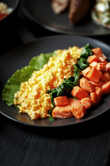Various culinary dishes on a dark wooden table. Exquisite restaurant serve on dark dishes