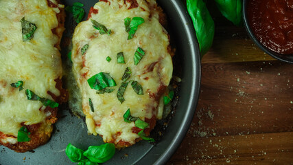 Homemade Chicken Parmesan topped with fresh basil leaves