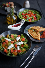 Various culinary dishes on a dark wooden table. Exquisite restaurant serve on dark dishes