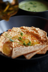 Various culinary dishes on a dark wooden table. Exquisite restaurant serve on dark dishes