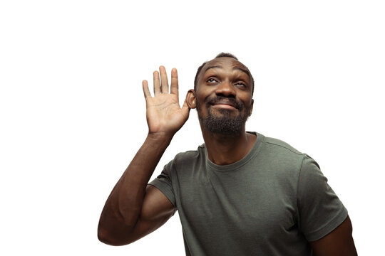 Listening. Young african-american man with funny, unusual popular emotions and gestures on white studio background. Human emotions, facial expression, sales, ad concept. Trendy look inspired by memes.