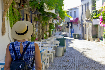 Young woman walking in narrow street in Alacati, Cesme Turkey