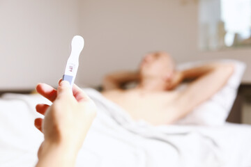 Sad adult caucasian couple with pregnancy test at home