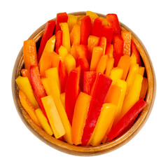 Bell pepper slices in a wooden bowl. Sweet pepper, capsicum or also called paprika, cut in colorful stripes. Fresh yellow, orange and red fruits of Capsicum annuum. Closeup from above macro food photo