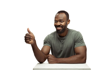 Like, thumb up. Young african-american man with funny, unusual popular emotions and gestures on white studio background. Human emotions, facial expression, sales, ad concept. Trendy look inspired by