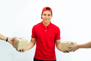 happy young delivery man in red cap standing with parcel post box