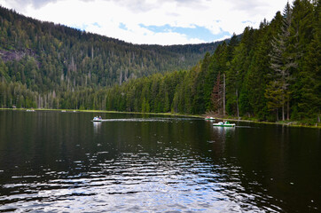 Greater Arber Lake (Grosser Arbersee) in Bavarian Forest, Germany, people in pedal boats, a cloudy day in summer, 