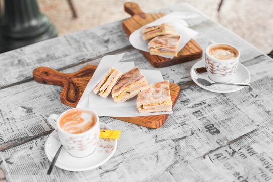 Traditional Portuguese breakfast - coffee with milk and a sandwich. Lunch in Madeira - 'bolo do caco' with ham and cheese