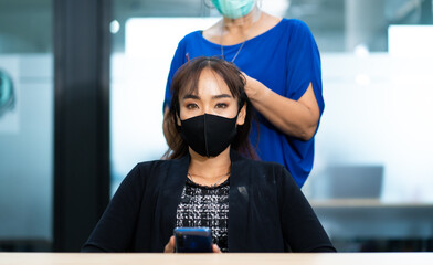 Young Asian woman at hairdresser salon wearing surgical protective face mask. New normal and social...