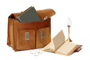 Arrangement with leather  bag , three books, eye wear and oil lamp isolated on white. Studio...