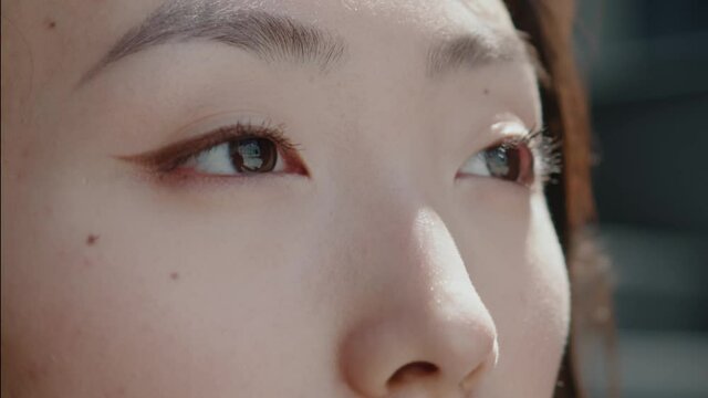 Gentle and beautiful young asian chinese woman opening eyes and looking straight to the side. Skin care, beauty, natural make-up. People. Faces.