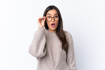 Young brunette woman over isolated white background with glasses and surprised