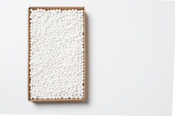 Cardboard box with white packing foam pellets, white polystyrene foam on a white background