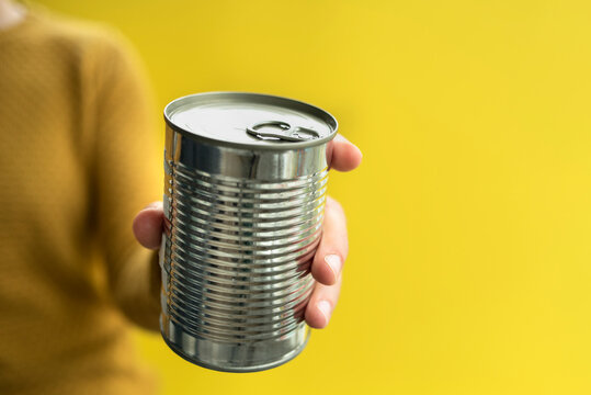 Woman holding steel can. Canned food