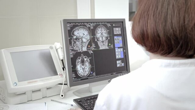 Doctor technician monitors an MRI scan. Magnetic resonance imaging in the study of the human body. The specialist is looking at the monitor in the laboratory.