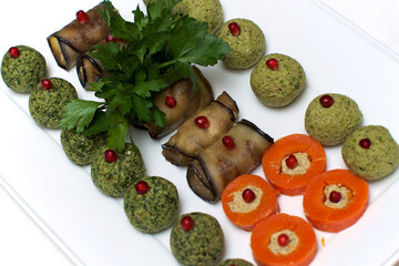 Festive dish with bright vegetarian snacks, decorated with greens