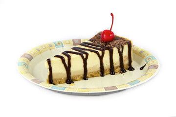 Isolated on a white background, a classic cheesecake, poured with chocolate syrup and sprinkled with chocolate chips, decorated with a cherry, standing on a plate