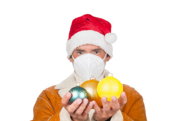 Man in Santa Claus hat and medical mask with christmas balls on white background
