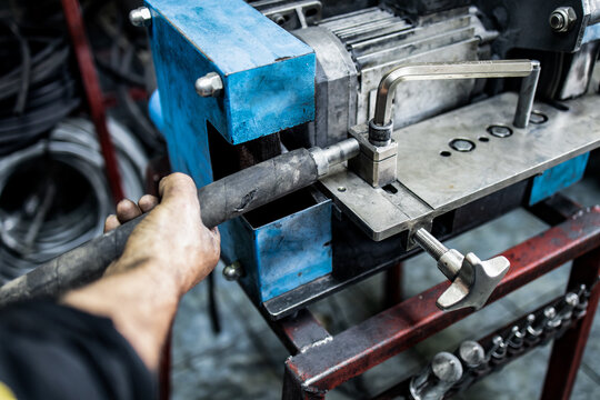 Worker, Cutting Hydraulic Hoses In A Metal Workshop