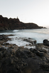 Fototapeta na wymiar lighthouse on the beach breaking waves