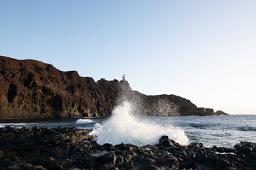 lighthouse on the beach breaking waves