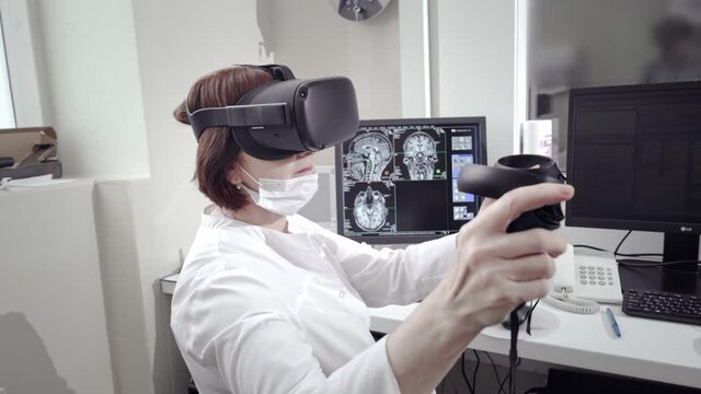 A real doctor performs an MRI scan for a patient at the clinic. Uses virtual reality technology in medicine, augmented reality. Magnetic resonance imaging in the study of the human body