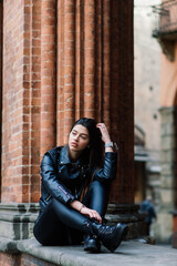 Portrait of beautiful young blonde woman wearing stylish black outfit, she smiling on urban background, happy time, Travel Concept.trendy girl in stylish sunglasses ad leather jacket in the street.