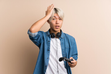 Young asian man over isolated background playing at videogames © luismolinero