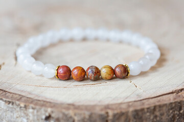Jasper and jade mineral stone beads bracelet on wooden background