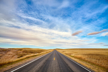 Obraz na płótnie Canvas Scenic road in Badlands National Park at sunset, travel concept, USA.
