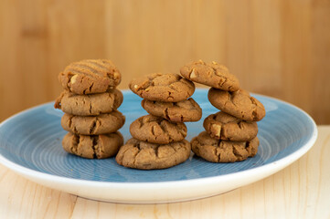 Very tasty peanut butter biscuits on bamboo light brown wooden board, golden baked healthy