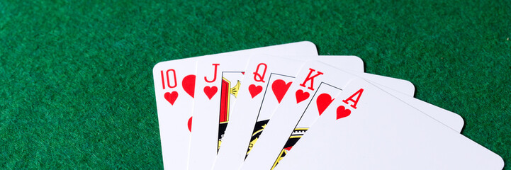 Panoramic image. Royal flush of hearts on green background. Winning hands of poker playing cards