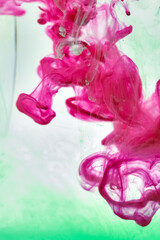 A photograph of Pink and Green colors mixed in water.