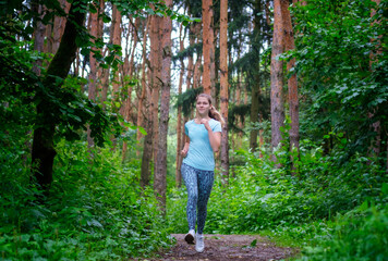 a young beautiful girl runs in a pine forest on a summer morning