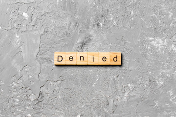 DENIED word written on wood block. DENIED text on cement table for your desing, concept