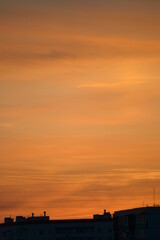 Fototapeta premium Flaming sunset sky in the city with roofs 