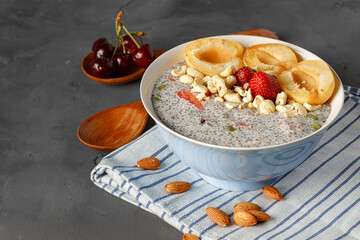 Bowl of chia poudding with pieces of apricots and strawberry