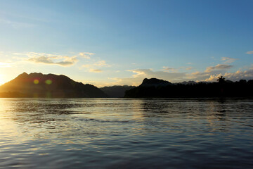 Mekong river flowing at dusk with moutains behind