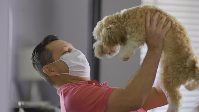 524 Man playing with his dog with a mask on
