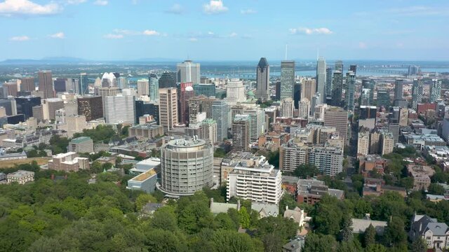 Drone flying and panning down towards Montreal downtown view on a sunny summer day