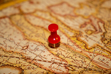 Red pin in vintage jigsaw puzzle map