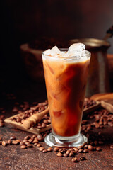 Ice coffee with cream being poured into it showing the texture and refreshing look of the drink.