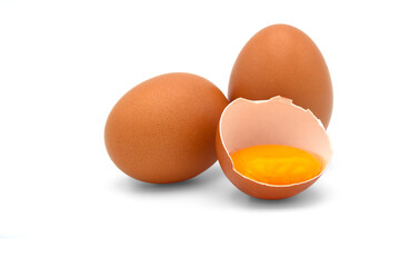 Eggs and a half of chicken egg with yolk in egg shell isolated on white background.