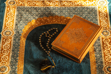 Rosary and Noble Quran on Praying Carpet with Natural Light 