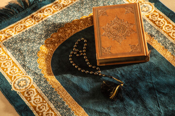 Rosary and Noble Quran on Praying Carpet with Natural Light 
