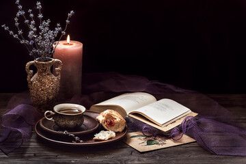Beautiful exquisite vintage still life. Bouquet of delicate flowers, a cup of coffee and an open book on a wooden dark background. Romantic composition. Copy space.