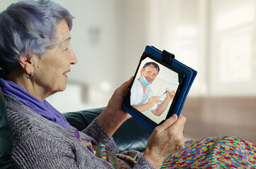 Telemedicine engages an elderly female patient to connect with her dentist in a convenient way. Doc explains her particular dental needs on the screen of the senior woman's tablet.