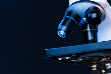 Microscope with lenses close up against dark background