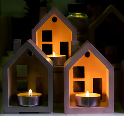 A small candlestick in the form of houses and burning candles inside. decorative home decoration. - 365012269